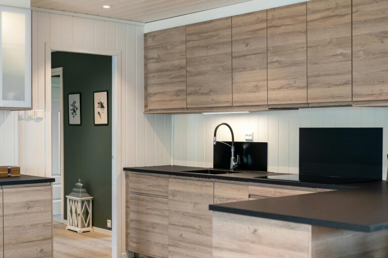 Sleek kitchen interior featuring wooden cabinets and black countertops.